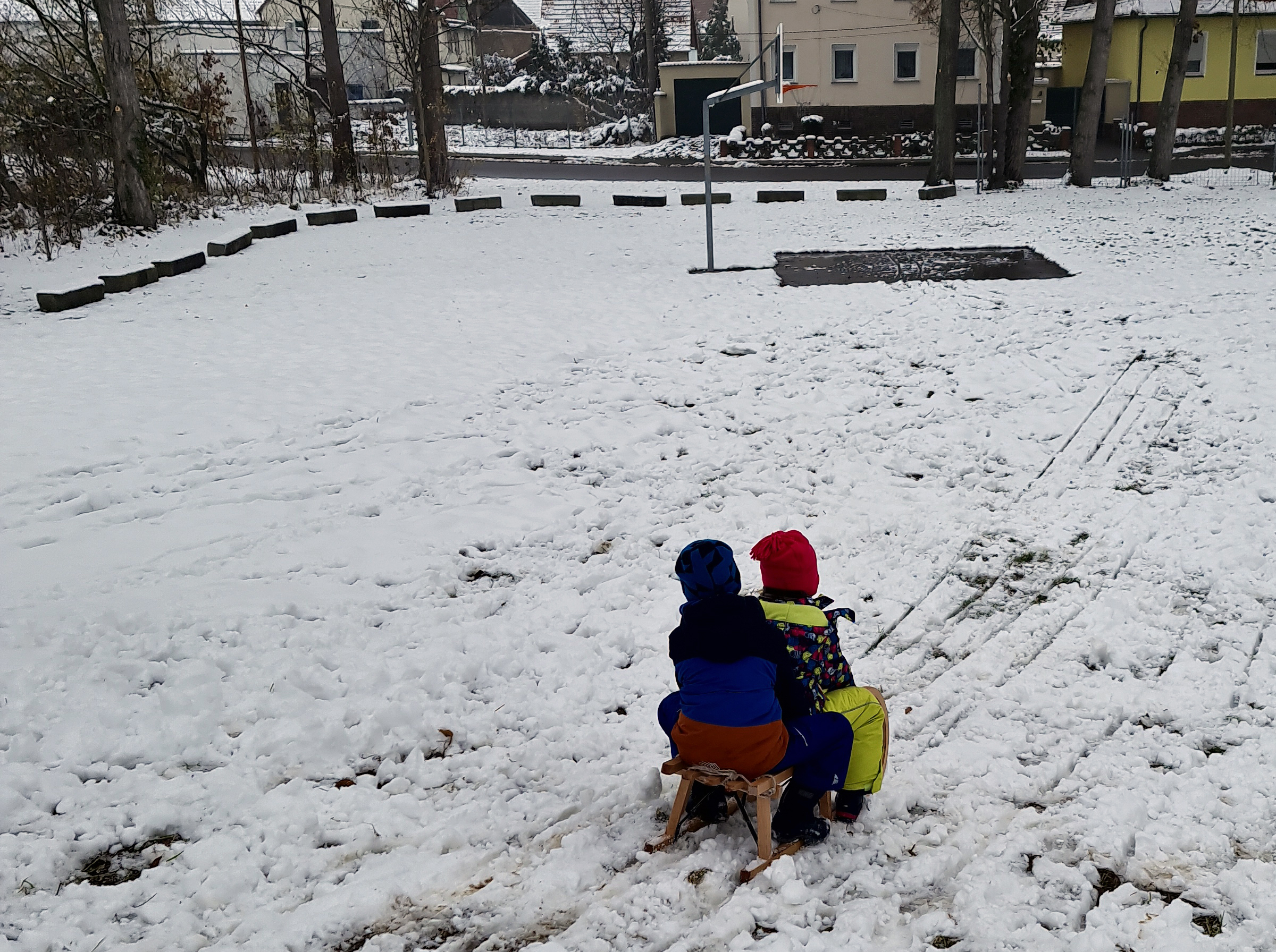 Foto: 2 Kinder auf dem Schlitten in Zöberitz auf dem Spielplatz